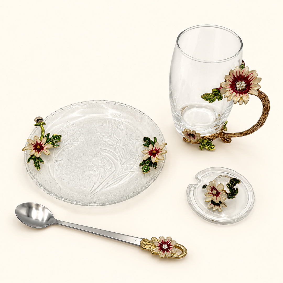 Glass tea cup and saucer set with metal pink and gold flowers laid out with lid and spoon