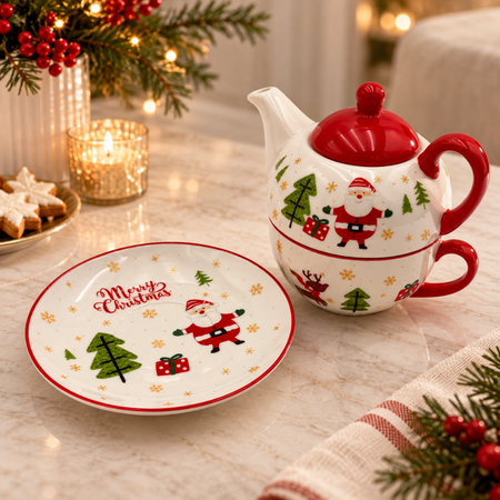 Santa teapot stacked on its cup beside the Merry Christmas saucer on a festive table